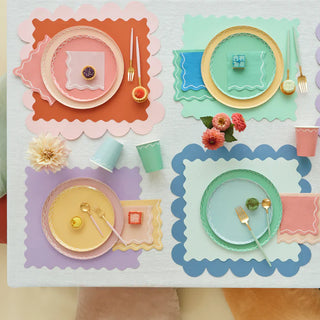 A table setting with colorful plates and napkins, perfect for a party table featuring Meri Meri Mixed Wavy Line Cups.