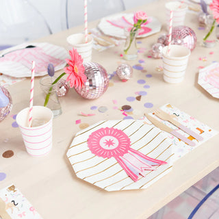 A pink and white party table set up for a girl's birthday with Daydream Society's Pony Tales Show Ribbon Guest napkins.