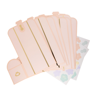 A stack of pastel pink planners with golden details, fanned out on a transparent background, featuring My Mind's Eye's Mermaid Treasure Treat Box Set.