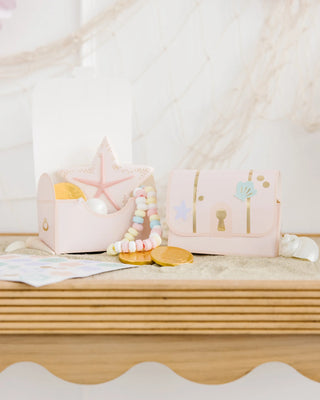 Mermaid Treasure treat boxes and rocking boat with pastel decorations on a sandy surface, complemented by a starfish, beads, and slices of orange from My Mind's Eye.