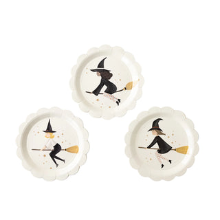 A set of three round, decorative My Mind’s Eye Witches Paper Plate Sets featuring illustrations of witches in various poses riding broomsticks, accented with star motifs and a delicate edge pattern.