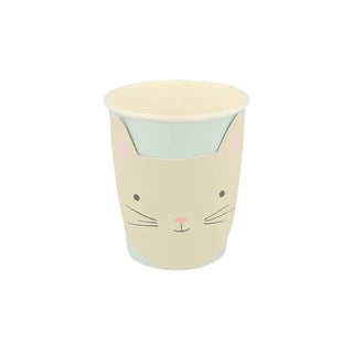 A cream-colored cup with a cute kitten face design, featuring simple whisker illustrations and a pastel color scheme made by Meri Meri's Kitten Cups.