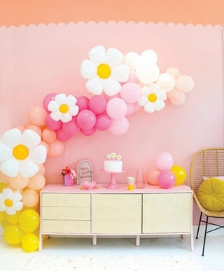 A pink and yellow room adorned with a Kailo Chic Daisy Balloon Garland kit and daisy balloons.