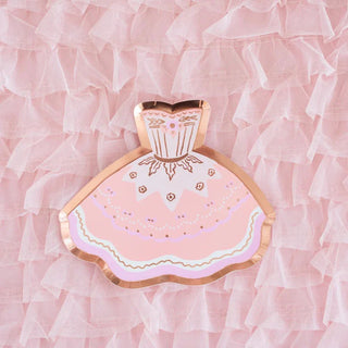 Pink and gold paper plate shaped like a dress on a pink ruffled fabric background.