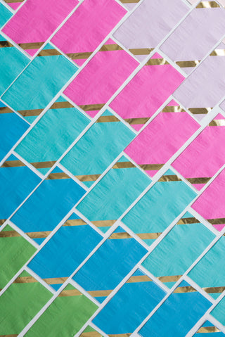 Colorful geometric pattern of pink, blue, green and white diagonal stripes forming a vibrant, dynamic lattice on a wall or surface.