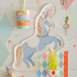 A festive unicorn-themed party setup with a pastel color palette, featuring a unicorn cutout, geometric patterns, confetti, and cheerful decorations on a light wooden surface.