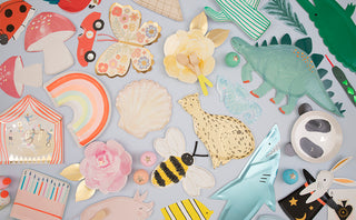 A vibrant collection of assorted paper cutouts including animals, flowers, and whimsical shapes, artistically scattered against a light background, depicting a playful and colorful montage.