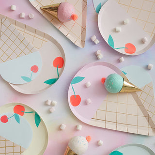 Flat lay of colorful paper art ice cream cones with abstract fruit designs, accompanied by mini marshmallows on a pastel background.