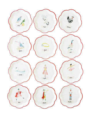 The 12 Days of Christmas Paper Plate Set by My Mind’s Eye includes twelve white holiday party plates with red trim, each displaying a unique visual representation and text label from the "12 Days of Christmas" song. Perfect for adding a festive touch to any Christmas gathering.