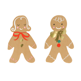 Two festively decorated gingerbread cookies; the one on the left sports a red bow, while the one on the right features a gold bow and buttons. Both have cheerful expressions and simple icing details, making them perfect additions to your Christmas party table alongside Meri Meri's Gingerbread Napkins with gold foil details.