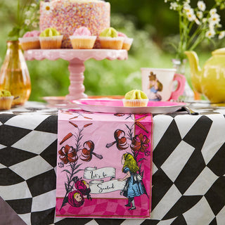 A table set for a whimsical tea party with a decorative tablecloth and a centerpiece cake; it features cupcakes, a teapot, and a cup adorned with Talking Tables' "Alice in Wonderland Pink Paper Napkins" reading "Let's be Social.