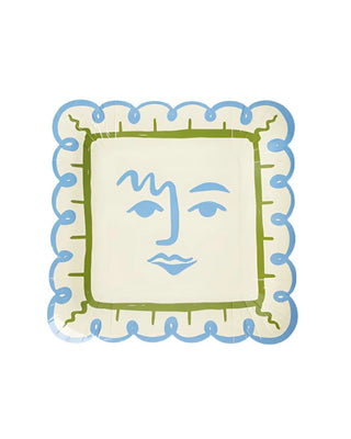 A square Art Party Dinner Plate from Pop! Party Supplies with a light cream background and a decorative border. It features a simplistic, abstract blue face design with green accents, echoing Picasso-inspired artistry. Made from sustainable FSC paper, it's perfect for environmentally conscious gatherings.