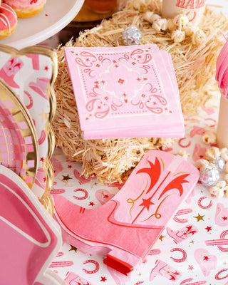Pink themed party table setting with My Mind's Eye boot-shaped paper dinner napkins, plates, and a straw backdrop.
