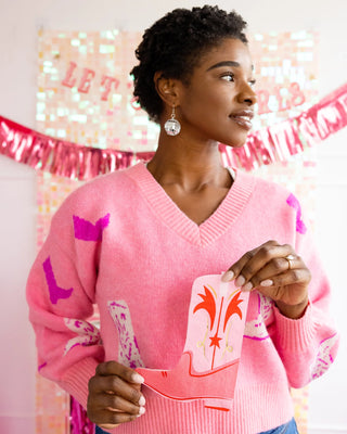 A woman in a pink sweater holds a Valentine's Day card, standing before a festive background with the text "letters of love," surrounded by My Mind’s Eye boot-shaped paper dinner napkins.