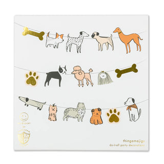 A whimsical square greeting card showcasing a variety of playfully illustrated dogs, bones, and paw prints strung along like party decorations, complete with a golden "good luck" charm from Daydream Society's Bow Wow Thingamajigs.