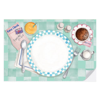 A dining table set with a plate, utensils, guest check, cup of coffee, salt and pepper shakers, glass of orange juice, and a small container of milk sits atop a teal and white checkered tablecloth is complemented by the Breakfast At the Diner Placemat Pad from Cami Monet. These fun watercolor placemats add a splash of color and ensure an easy-breezy cleanup.