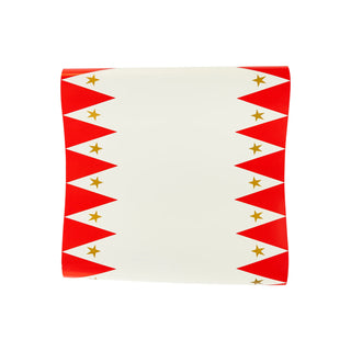 A rectangular sheet of My Mind’s Eye Carnival Paper Table Runner with red triangular borders featuring whimsical gold foil stars on each side.