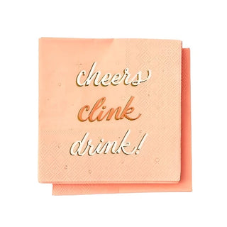 Two chic, peach-colored napkins with the words "cheers clink drink!" written in gold foil accents on the top Cheers Clink Drink Disposable Napkin by Paper Source.