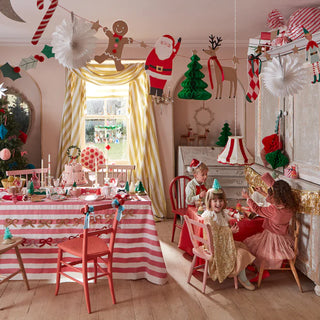 A children's Christmas party in a room decorated with Meri Meri's Christmas Characters Garland.