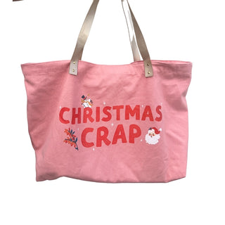 The Christmas Crap Oversized Tote Bag by Fun Club is a pink holiday tote with beige handles, featuring the words "CHRISTMAS CRAP" printed in red. Adorned with small festive illustrations such as a snowman, holly, and Santa Claus, its vibrant colors make this bag perfect for adding some holiday cheer to your shopping trips.