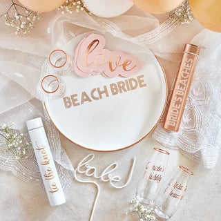 A cocktail napkin with balloons and a cocktail napkin with the word "beach bride", perfect for a Valentine's Day celebration by Creative Brands.