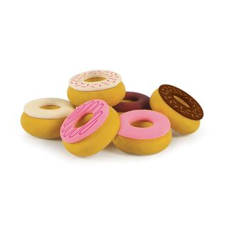 A collection of vibrant Fred and Friends Donut Erasers, in a variety of icing colors such as pink, white, and brown—some adorned with sprinkles—are piled together. These BPA-free donut erasers not only serve as playful toys but also exude a charming vanilla scent.