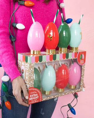 A woman holding a box of Packed Party Extra Bright Mini Light Sippers Set of 4.