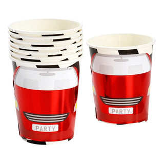 A stack of six red paper cups next to one standalone cup, all featuring vibrant car designs with the word "PARTY" on the license plate area—Talking Tables F1 Red Race Car Paper Cups are perfect kids party cups for an exciting F1-themed celebration.