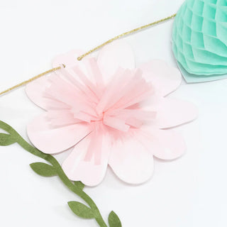 The Meri Meri Fairy Garland features a delicate paper flower decoration with a pink center and white petals, complemented by a green leaf-shaped ribbon and a mint-green honeycomb ball, perfect for adding charm to fairy party or princess party décor, all set against a pristine white background.