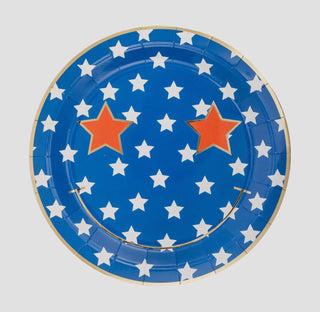 A Star & Stripe Smiley paper plate set from My Mind's Eye, decorated with white stars and two larger orange stars, suitable for a USA-themed event, isolated on a white background.