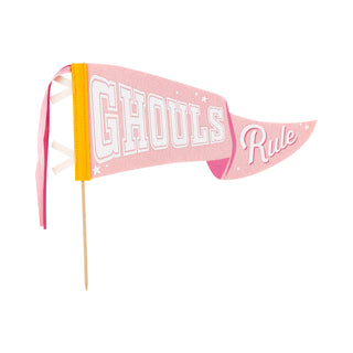 The Ghouls Rule Felt Pennant Banner by My Mind’s Eye features a pink felt design with "Ghouls Rule" in white text. This Halloween decor, attached to a wooden stick, is perfect for adding a festive touch.