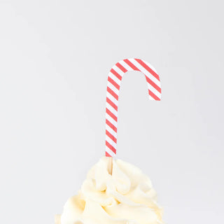 A candy cane stick inserted into a swirl of white cream frosting makes a festive topper, ideal for any Gingerbread Cupcake Kit from Meri Meri.