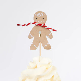 This delightful gingerbread man topper from the Meri Meri Gingerbread Cupcake Kit, adorned with a red and white striped scarf, is nestled in whipped cream frosting. Perfect for a creative gift, this festive accessory is sure to enhance any celebration.