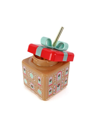 A Gingerbread House Novelty Sipper adorned with a bow, perfect for the Christmas spirit.