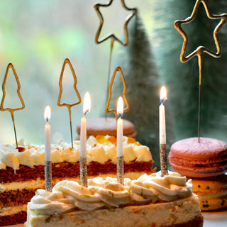 A cake with Glitter Wish Candles Beeswax Gold celebration candles by Tops Malibu on top of it.