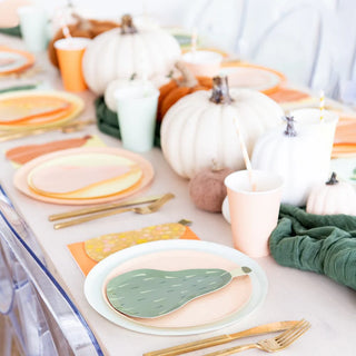 A table set with autumn-themed decorations, including white pumpkins, Jollity & Co's Gourd Dessert Plates with unique die-cut designs, cups, and gold utensils. The color scheme features soft pastels and earthy tones, perfect for a festive Thanksgiving gathering.