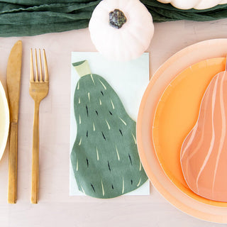 A table setting with gold cutlery, Jollity & Co's Gourd Large Napkins folded and shaped like pumpkins, orange plates, and small white decorative pumpkins—a perfect pack of 16 to elevate your holiday spirit.