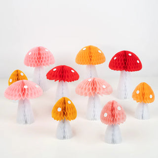 A group of Meri Meri honeycomb mushroom decorations on a white surface, creating a 3D effect.