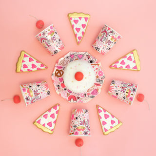 A donut topped with a cherry is surrounded by heart and rainbow-themed cups and cake slices, all elegantly displayed on Love Notes Plates by Daydream Society, set against a pink backdrop with delicate gold foil accents.