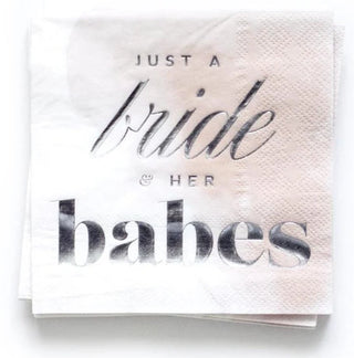 Close-up of a white cocktail napkin with metallic text that reads "Just a Bride & Her Babes - Blush Cocktail Party Napkins" by Kitty Meow Boutique, perfect for bachelorette parties and bridal showers.