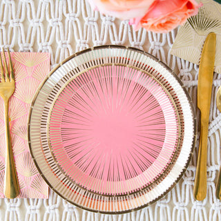 A pink decorative plate on a patterned placemat captures La Boheme's allure, featuring Jollity & Co's pink La Boheme Cocktail Napkins and gold cutlery. A bouquet with pink flowers adds a summer birthday charm to the setting, perfect for an elegant party.