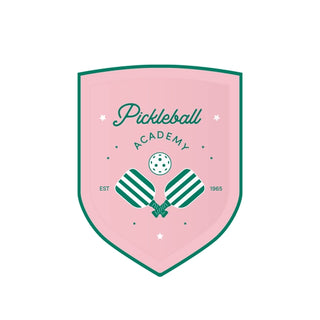 A Le Pickleball Small Plates for the "pickleball academy" with green crossed paddles, a pickleball made from eco-conscious materials, and stars, indicating establishment in 1965.
