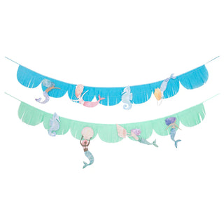 The Mermaid Fringe Garland by Meri Meri features two fringed tissue paper garlands adorned with hanging mermaid tails and seashells in pastel tones on blue and green fringed banners, making it the perfect decoration for a mermaid-themed party.