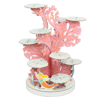 Introducing the Talking Tables Mermaid Party Cake Stand, a delightful 3D puzzle model featuring a pink coral structure with white platforms and a charming figure of a girl at the base, making it the perfect plastic-free centerpiece for any mermaid-themed children's party.