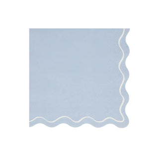 A Mixed Wavy Line Large Napkin from Meri Meri with a blue color and white trim for a party table.