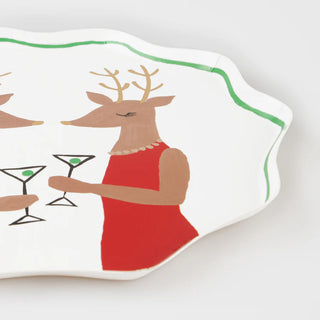 The Mr. & Mrs. Reindeer Side Plates by Sprinkle BASH feature a decorative paper design with a whimsical illustration of a deer in a red dress holding a martini glass, making them perfect for adding charm to your Christmas meal or festive tableware display.