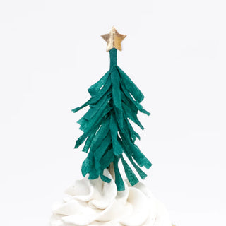 A cupcake adorned with white frosting rests gracefully in a gold foil cupcake case, crowned with a green paper decoration that resembles a Christmas tree and features a shimmering gold star, all part of the Nutcracker Cupcake Kit by Meri Meri.