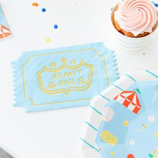 A table with a cake, cupcakes, and Off to the Fair Admit One Napkins perfect for circus parties by Daydream Society.
