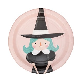 The Pink Monster Plate Set by My Mind’s Eye features a pink paper plate adorned with an illustration of a smiling witch in a black hat, green hair, and black dress with a white collar. Perfect for Halloween parties!