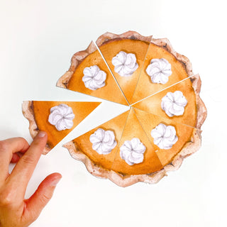 A hand is picking up a slice from a Cami Monet Pumpkin Pie Party Punchies that features whipped cream dollops on each slice, arranged on a white surface adorned with festive party decorations.